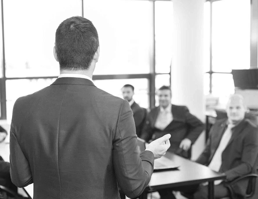 A financial expert giving a formal presentation to a group of professionals.