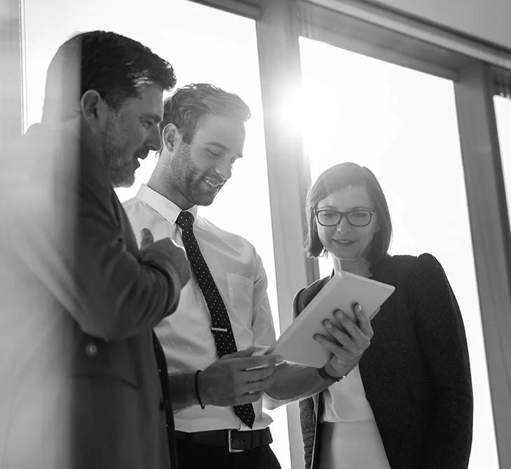Financial experts looking at a document, engaged in a fun, casual conversation in a relaxed office setting.